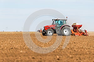 Farmer seeding, sowing crops at field.