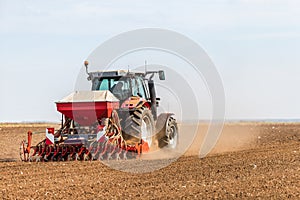 Farmer seeding, sowing crops at field.