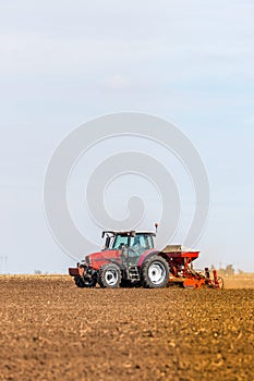 Farmer seeding, sowing crops at field.