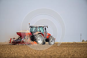 Farmer seeding, sowing crops at field.