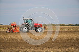 Farmer seeding, sowing crops at field.