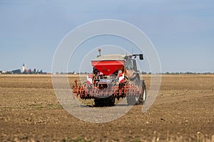 Farmer seeding, sowing crops at field.