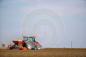 Farmer seeding, sowing crops at field.