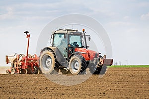 Farmer seeding, sowing crops at field.