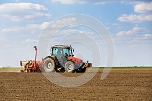 Farmer seeding, sowing crops at field.