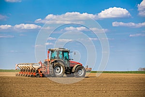 Farmer seeding, sowing crops at field.