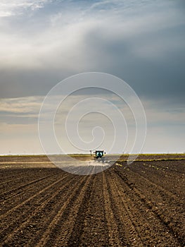 Farmer seeding, sowing crops at field.