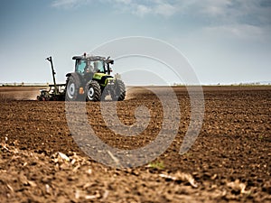 Farmer seeding, sowing crops at field.
