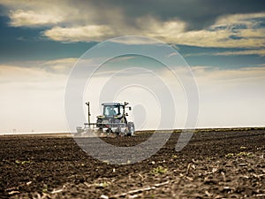 Farmer seeding, sowing crops at field.