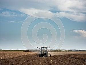 Farmer seeding, sowing crops at field.