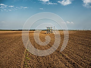 Farmer seeding, sowing crops at field.