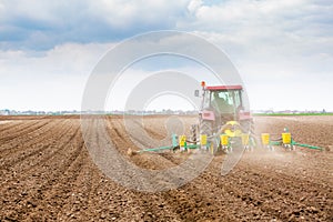 Farmer seeding, sowing crops at field. Sowing is the process of planting seeds in the ground as part of the early spring time agri