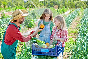 Farmer showing vegetables harvest to kid girls