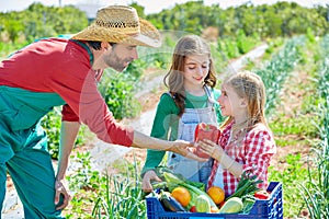 Farmer showing vegetables harvest to kid girls