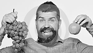 Farmer shows harvest. Winegrower with excited face holds grapes