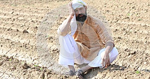 Farmer is sitting in a agricultural field during the long drought