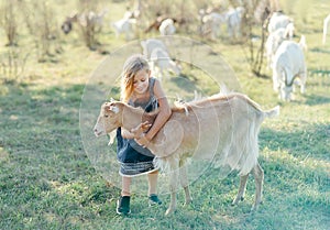 farmer with small goatlings on goats farm