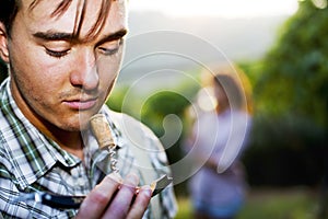 Farmer sniffing wine cork to test the quality of the wine