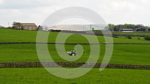 Farmer spreading fertiliser in fields outside Manchester in Northern England