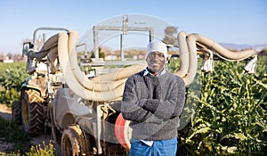 Farmer standing near tractor with fumigator