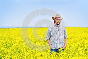 Farmer Standing in Oilseed Rapeseed Cultivated Agricultural Fiel photo