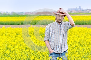 Farmer Standing in Oilseed Rapeseed Cultivated Agricultural Field photo