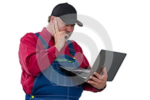 Farmer standing reading a handheld laptop computer