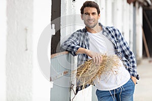 farmer stood in front bails hay