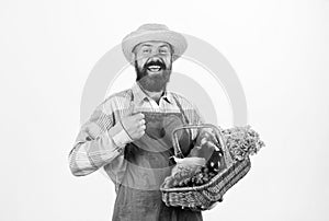 Farmer straw hat hold eggplant and basket vegetables. Fresh organic vegetables wicker basket. Man bearded presenting