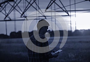 Farmer with tablet in front of irrigation system