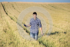 Farmer with tablet in wheat field