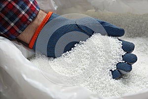Farmer taking pellets of ammonium nitrate from bag, closeup. Mineral fertilizer