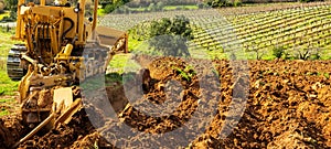 Farmer tills the soil with the crawler tractor. Agriculture