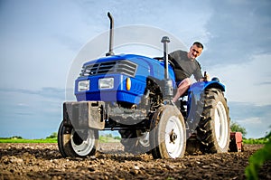 A farmer on a tractor cleans the field after harvest. Preparation of land for future planting new crop. Intensive land use.