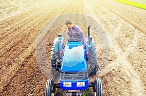 A farmer on a tractor cultivates a farm field. Soil milling, crumbling and mixing. Preparatory work for a new planting. Loosening