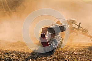 Farmer tractor with disc harrow system working on a stubble field