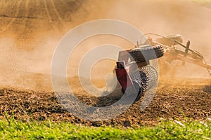 Farmer tractor with disc harrow system working on a stubble field