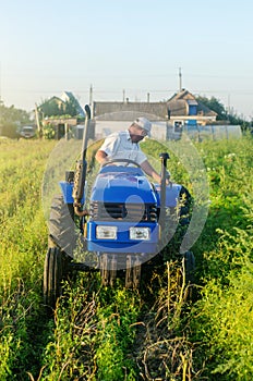 A farmer on a tractor drives across the farm field and harvests. Farming, agriculture. Improving agricultural practices using