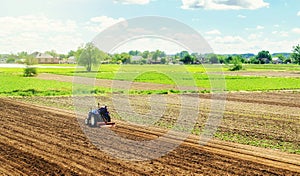 Farmer on a tractor with milling machine loosens, grinds and mixes ground. Cultivating land soil for further planting. Loosening,