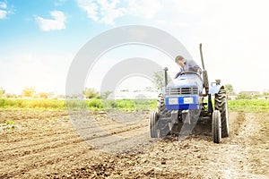 Farmer on a tractor with milling machine loosens, grinds and mixes soil. Loosening surface, cultivating the land for further