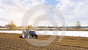 Farmer on a tractor with milling machine loosens, grinds and mixes soil. Loosening the surface, cultivating the land for further