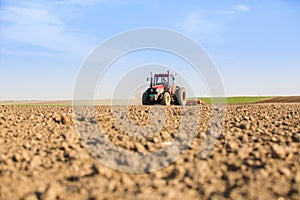 Farmer in tractor preparing land with seedbed cultivator