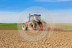 Farmer in tractor preparing land with seedbed cultivator