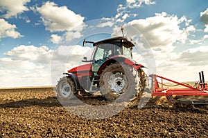 Farmer in tractor preparing land with seedbed cultivator