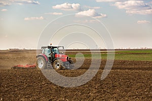 Farmer in tractor preparing land with seedbed cultivator