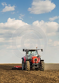 Farmer in tractor preparing land with seedbed cultivator