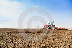 Farmer in tractor preparing land with seedbed cultivator