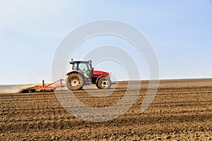 Farmer in tractor preparing land with seedbed cultivator