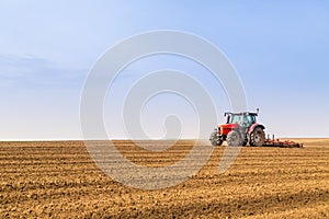 Farmer in tractor preparing land with seedbed cultivator