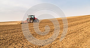 Farmer in tractor preparing land with seedbed cultivator